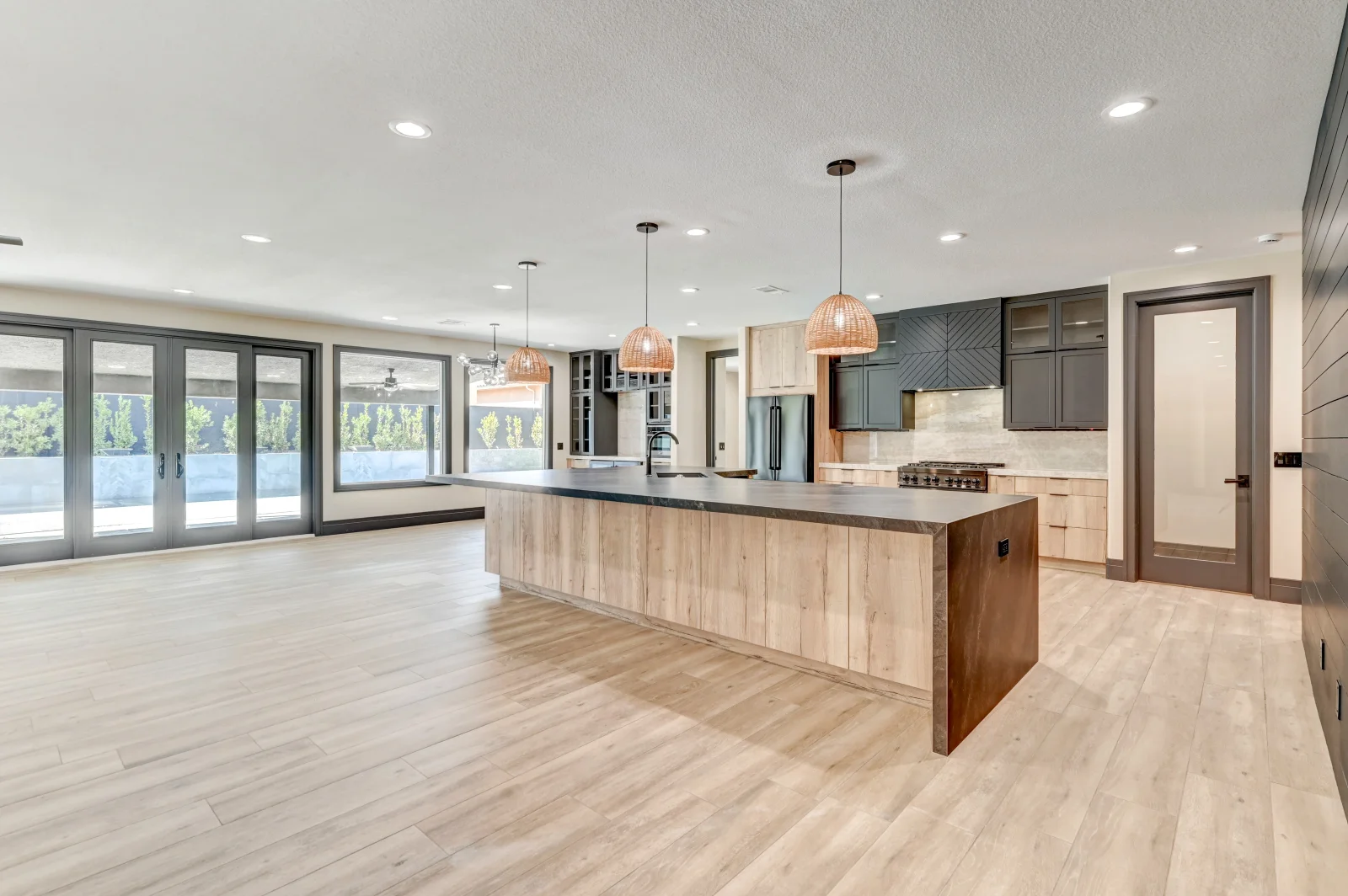 Modern kitchen with wood cabinetry, quartz island, stainless steel appliances, and waterfront views